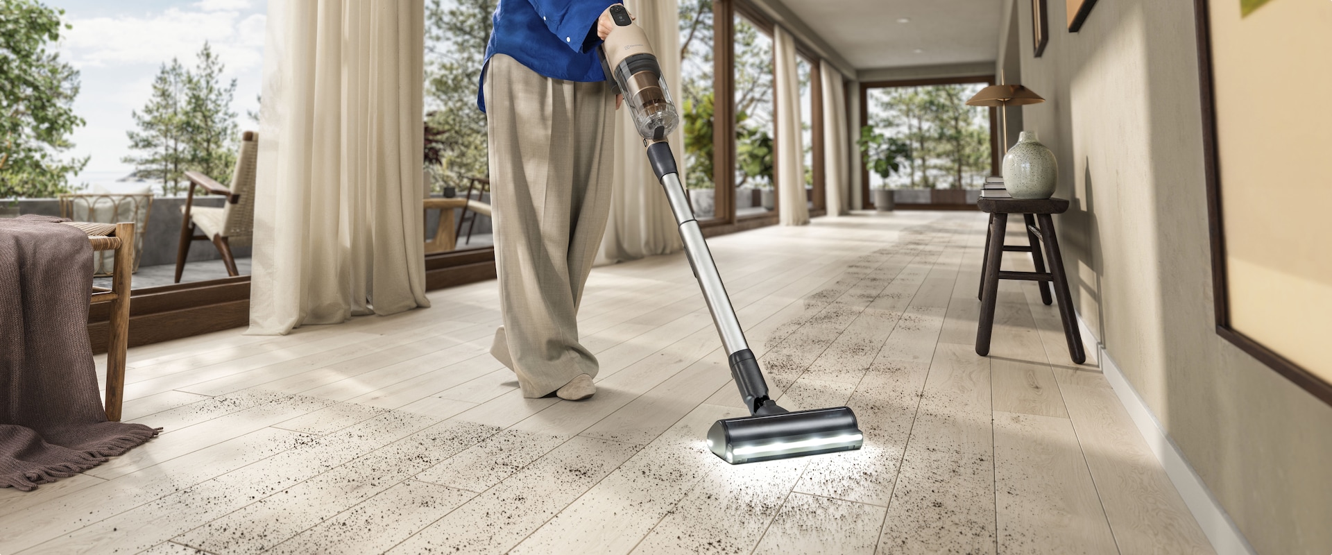 Egy férfi álló porszívóval takarítja a padlót.